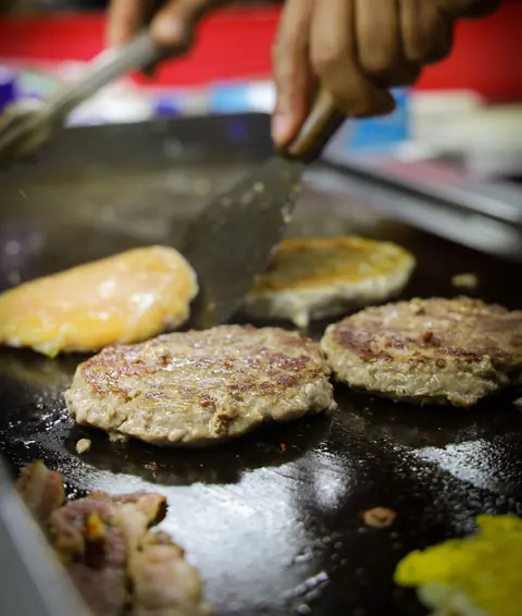 Burger patties sizzling on a flat-top grill